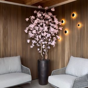 Zacht roze gekleurde bloesemboom in kopere sepia pot